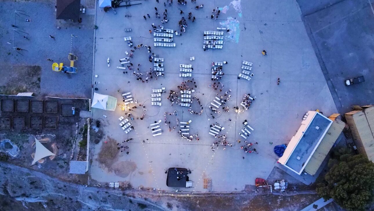 aerial view of groups of people in chairs on an outdoor court.