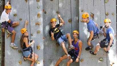 rock climbers on an artificial wall smiling for the camera.