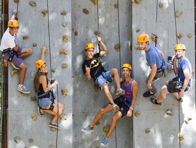 rock climbers on an artificial wall smiling for the camera.