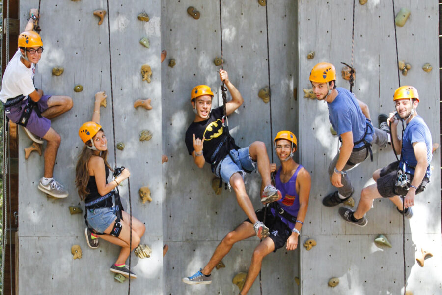 rock climbers on an artificial wall smiling for the camera.
