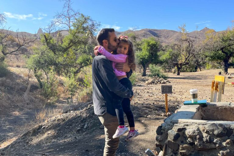 father holding daughter outside.