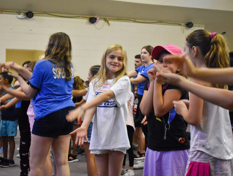 group of girls dancing and singing indoors.