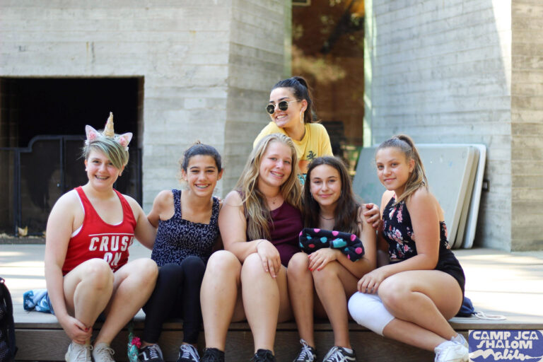 group of teen girls sitting and smiling.