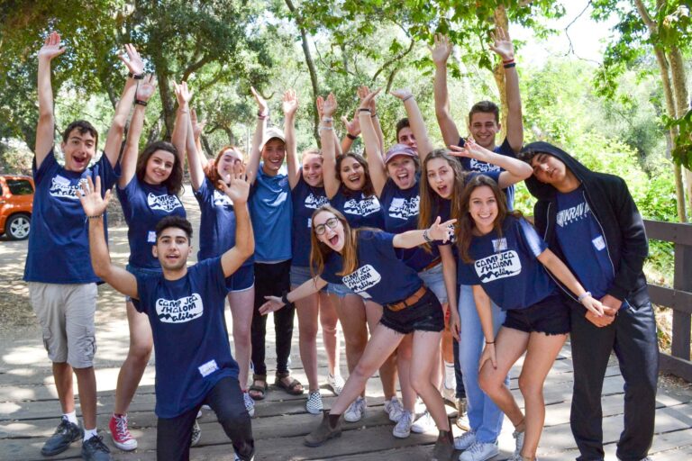 group of happy camp counselors in blue shirts.