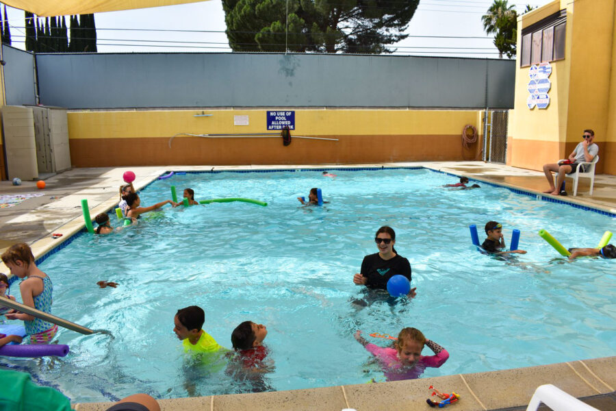 kids swimming in an outdoor pool.