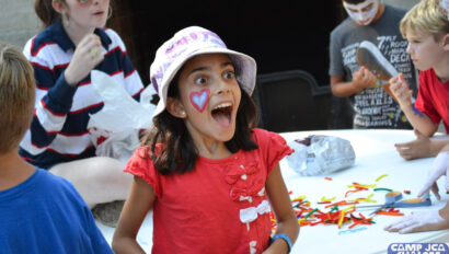 excited and surprised girl with her mouth open in front of a few other kids.