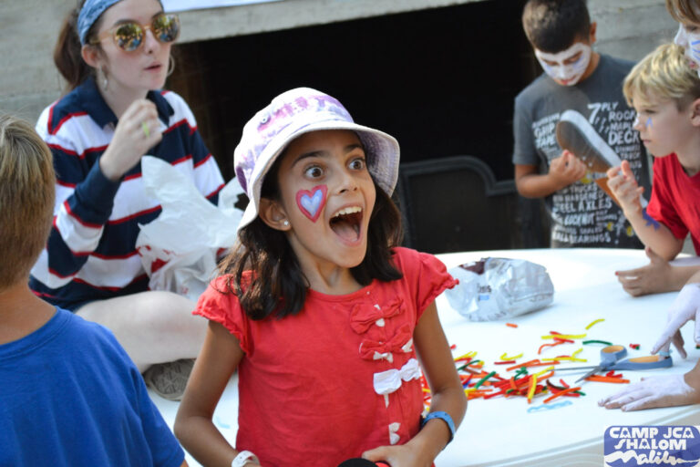 excited and surprised girl with her mouth open in front of a few other kids.