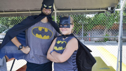 two people posing dressed up as batman.